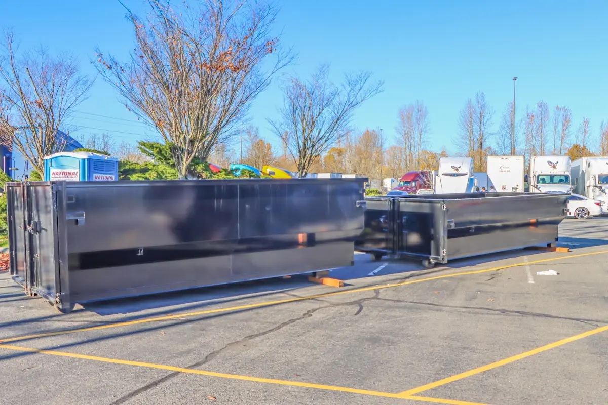 Professional dumpster rental service with roll-off container on residential driveway in Parkville